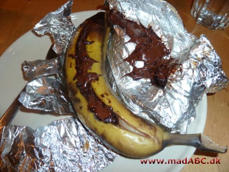 Bananer på grillen Spændende dessert med banan, der kunne være perfekt en lun sommeraften, da retten skal grilles. Desserten kan laves i to version med enten kanelsukker eller chokolade, begge gode.