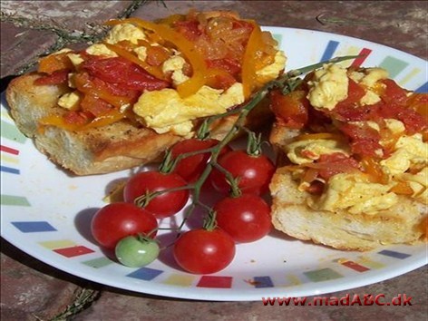 Omeletter spises i Baskerlandet også på brød. En forskel er her, at æggekagen laves i ovnen. Her er den lavet med pølser, som dog ikke er en nødvendighed. Pynt gerne med tomat og agurk.