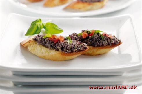 Crostini med tapenade Disse crostini skal simpelthen smages! Verdens mest geniale olivenpasta - desværre ikke opfundet af os. Brug den som aperitif. Server gerne med et glas vin eller to.