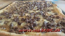 Pizza med banan og chokolade Denne pizza er nok mere en dessert end et egentlig måltid, men den smager ikke desto mindre super lækkert. prøv den for eksempel til en børnefødselsdag. Nødderne kan eventuelt undlades.