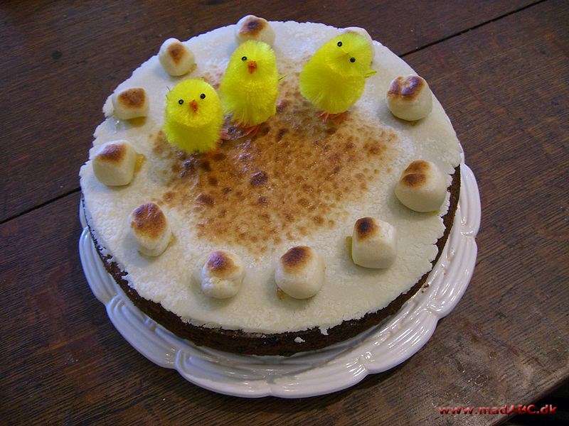 Pynt kagen med et gult silkebånd samt påskekyllinger og små påskeæg.